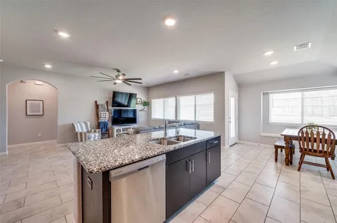 a kitchen with granite countertop sink table and chairs