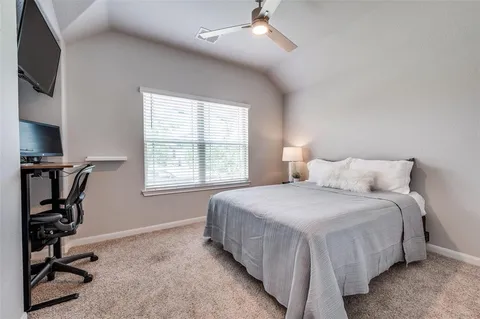 a bedroom with bed tv and window