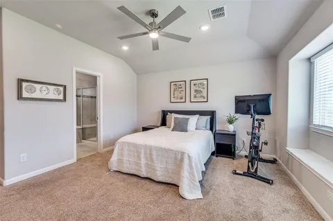 a bedroom with a bed desk and a window