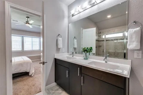 a en suite bathroom with a double vanity sink and mirror