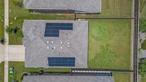 a aerial view of a brick house next to a yard