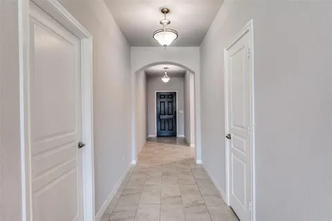 a view of a hallway with wooden floor and a chandelier