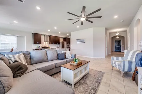 a living room with furniture kitchen view and a window
