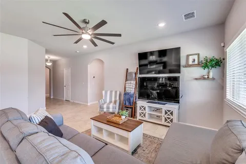 a living room with furniture a window and a flat screen tv