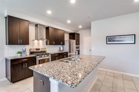 a kitchen with stainless steel appliances granite countertop a sink stove and refrigerator