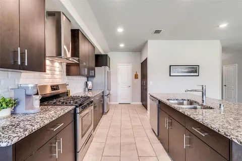 a kitchen with stainless steel appliances granite countertop a sink stove and cabinets
