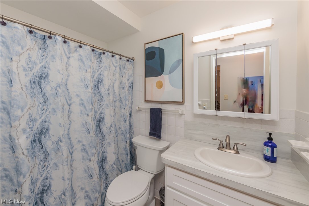 1750 Wagar Road, Unit 206 Rocky River, OH 44116 - Photo 23 of 33 Bathroom featuring oversized vanity, backsplash, mirror, and tile walls