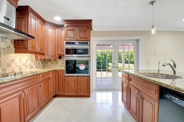 a kitchen with granite countertop a refrigerator and a sink