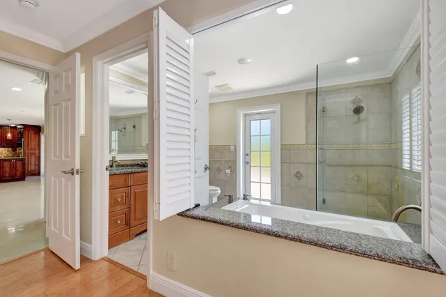 a bathroom with a granite countertop sink mirror vanity and a bathtub