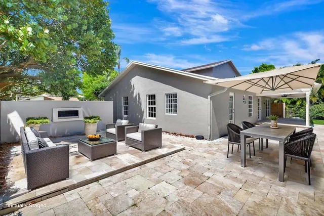 front view of a house with a yard and potted plants