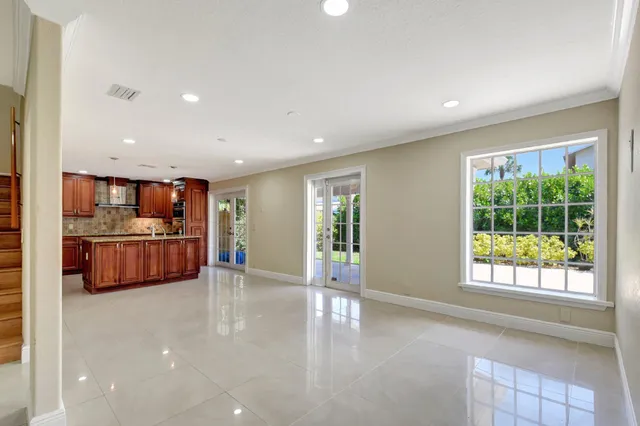 a kitchen with kitchen island granite countertop a sink cabinets and window