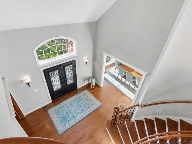 a kitchen with stainless steel appliances granite countertop a kitchen island a stove a refrigerator a sink a dining table and chairs with wooden floor