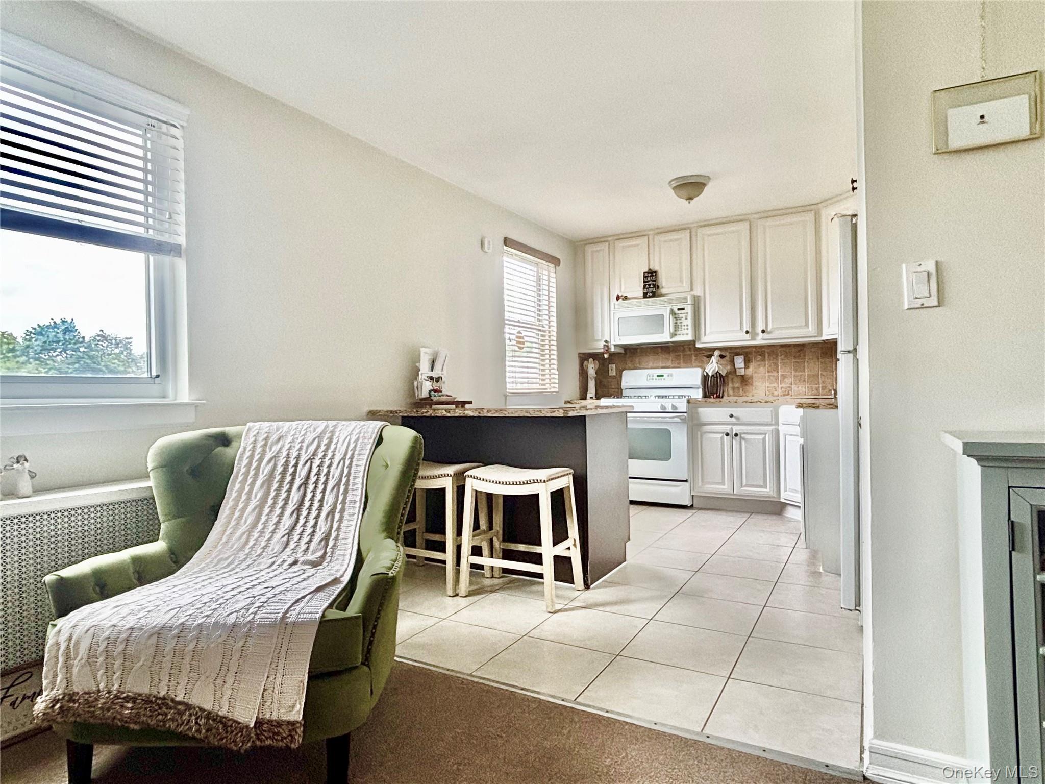 72-29 Little Neck Parkway, Unit 2 Queens, NY 11426 - Photo 12 of 24 a living room with a bed and furniture kitchen view