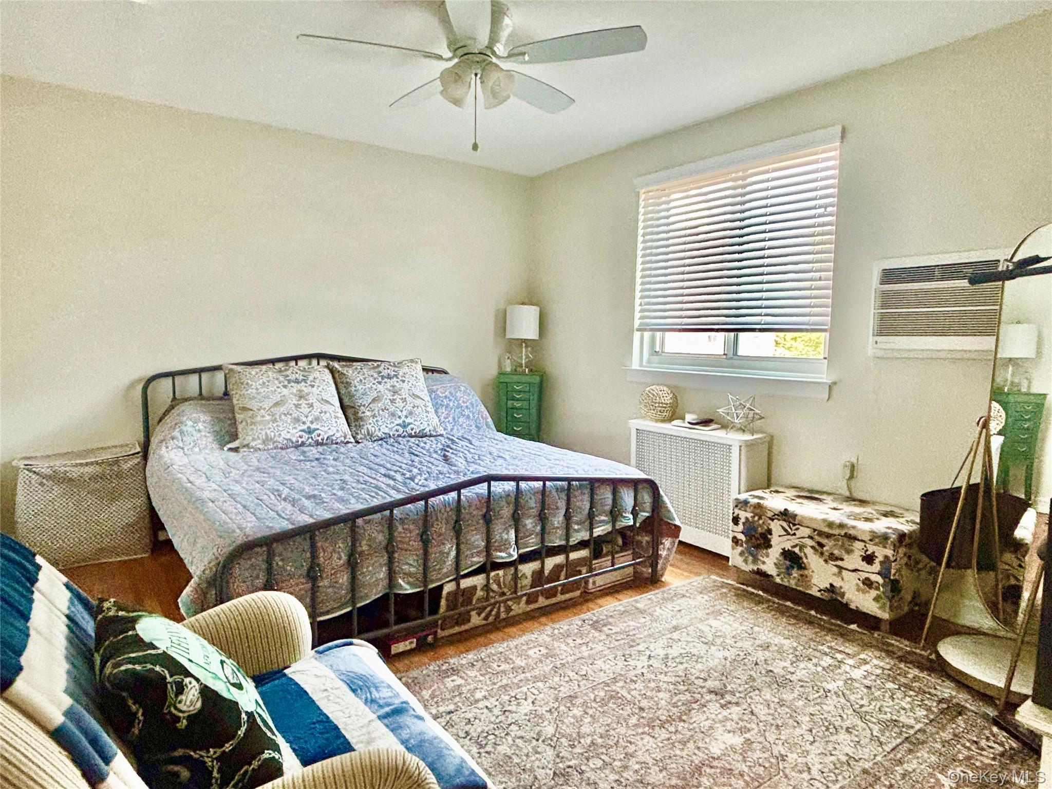 72-29 Little Neck Parkway, Unit 2 Queens, NY 11426 - Photo 16 of 24 a bedroom with a bed and wooden floor