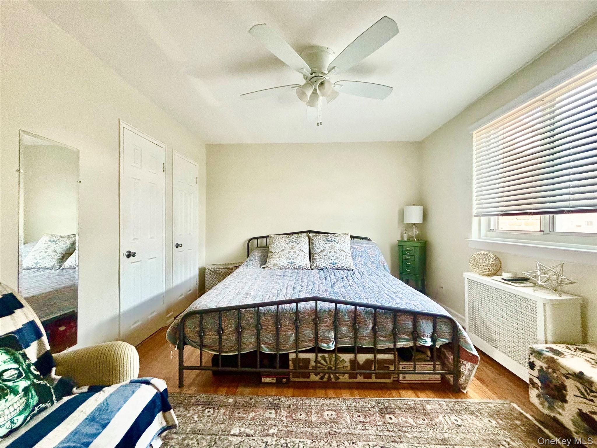 72-29 Little Neck Parkway, Unit 2 Queens, NY 11426 - Photo 17 of 24 a bedroom with a bed and a chandelier