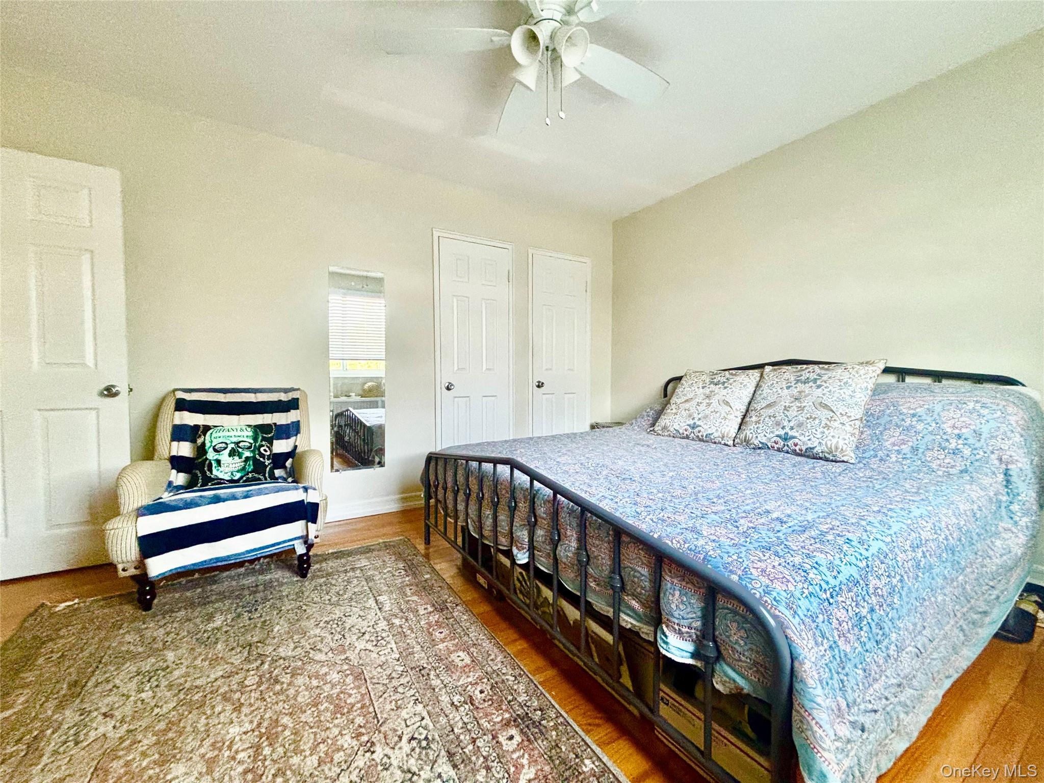 72-29 Little Neck Parkway, Unit 2 Queens, NY 11426 - Photo 18 of 24 a bedroom with a bed and a chandelier