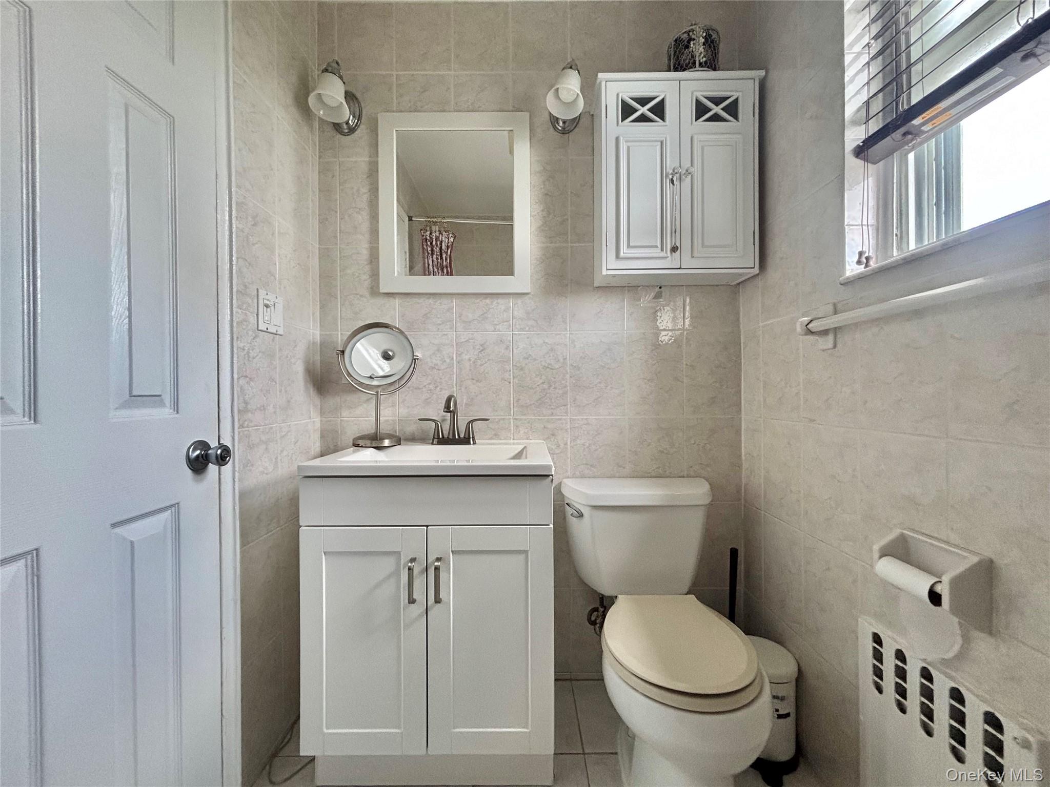 72-29 Little Neck Parkway, Unit 2 Queens, NY 11426 - Photo 20 of 24 a bathroom with a toilet a sink and mirror