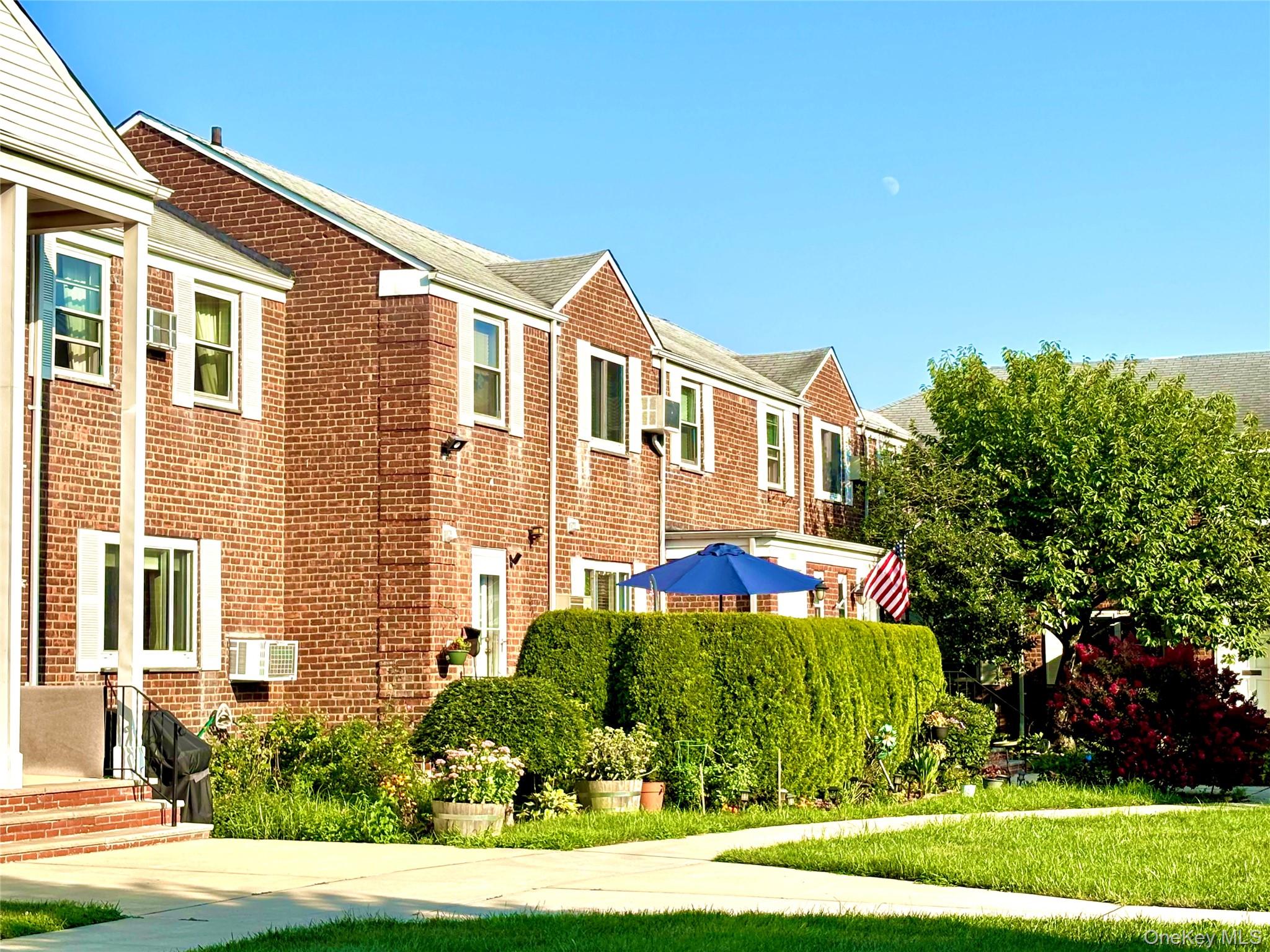 72-29 Little Neck Parkway, Unit 2 Queens, NY 11426 - Photo 2 of 24 a front view of a house with a garden