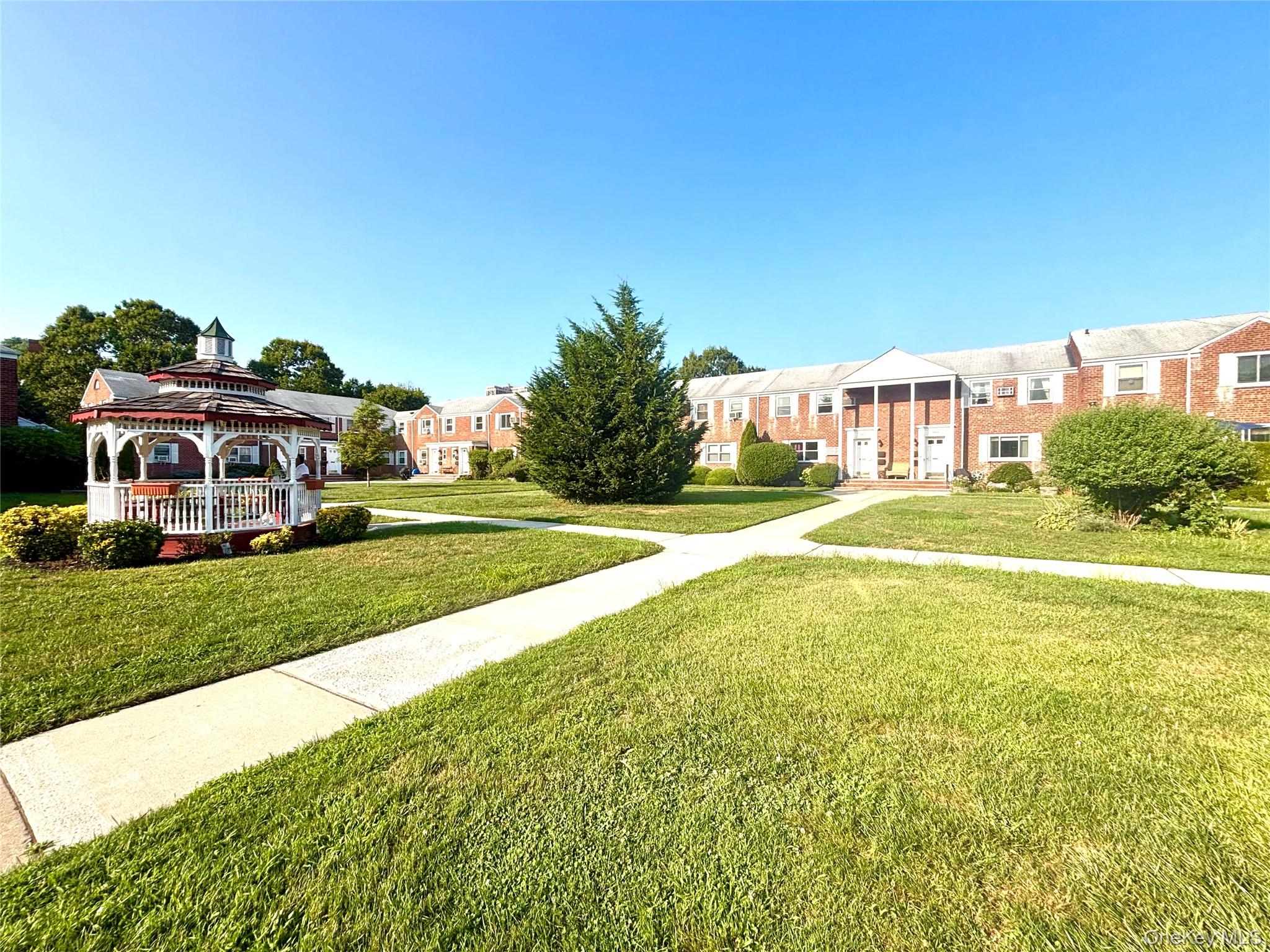 72-29 Little Neck Parkway, Unit 2 Queens, NY 11426 - Photo 22 of 24 a front view of a house with a yard