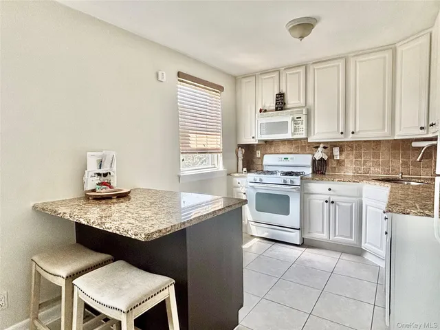 a kitchen with cabinets appliances and a window