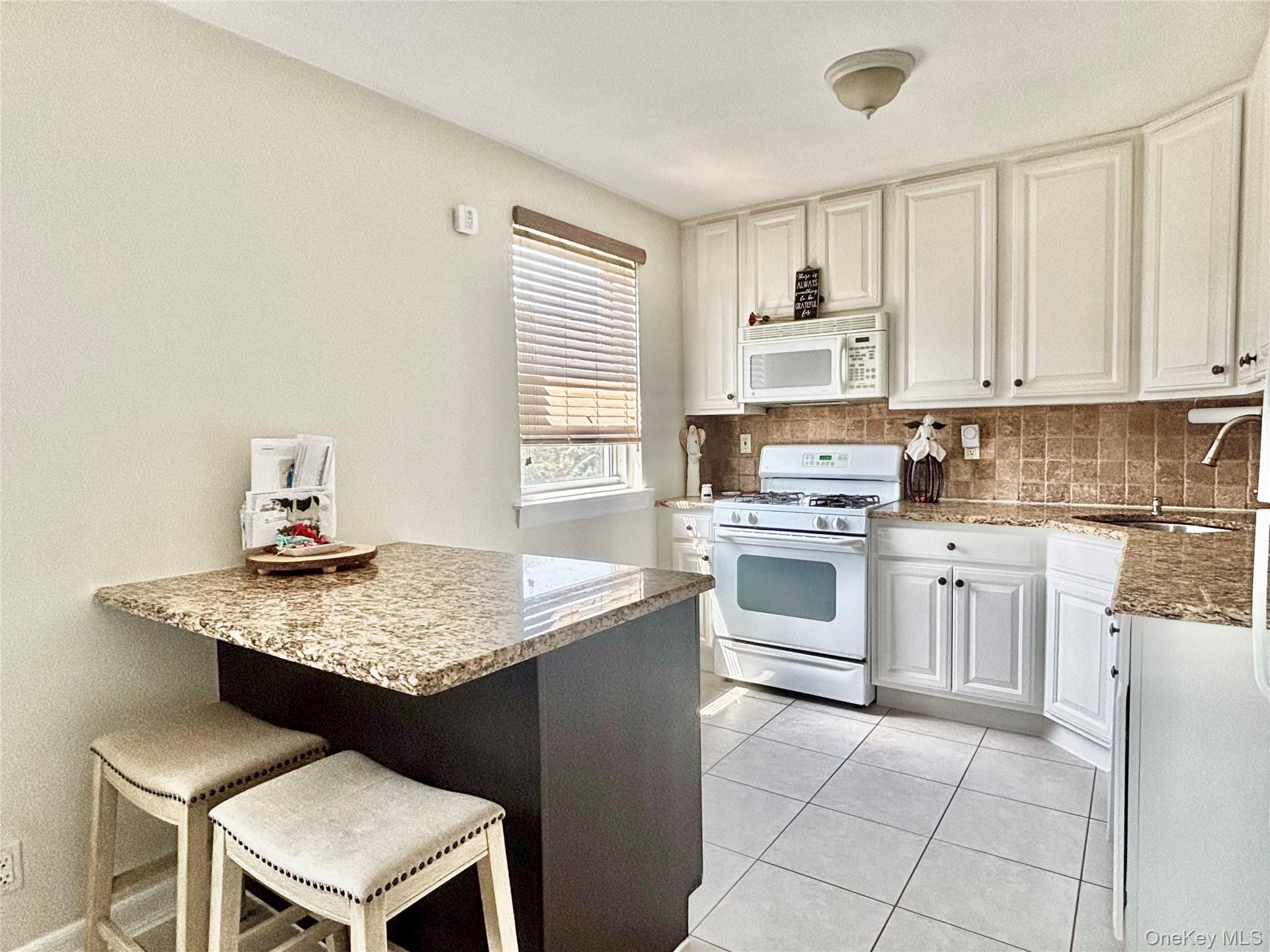 72-29 Little Neck Parkway, Unit 2 Queens, NY 11426 - Photo 3 of 24 a kitchen with cabinets appliances and a window