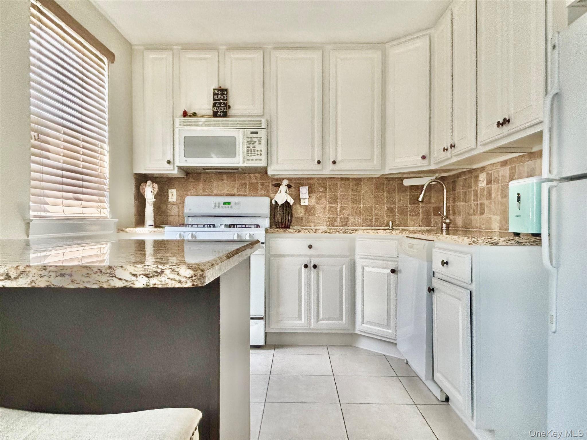 72-29 Little Neck Parkway, Unit 2 Queens, NY 11426 - Photo 4 of 24 a kitchen with stainless steel appliances granite countertop a sink window and cabinets
