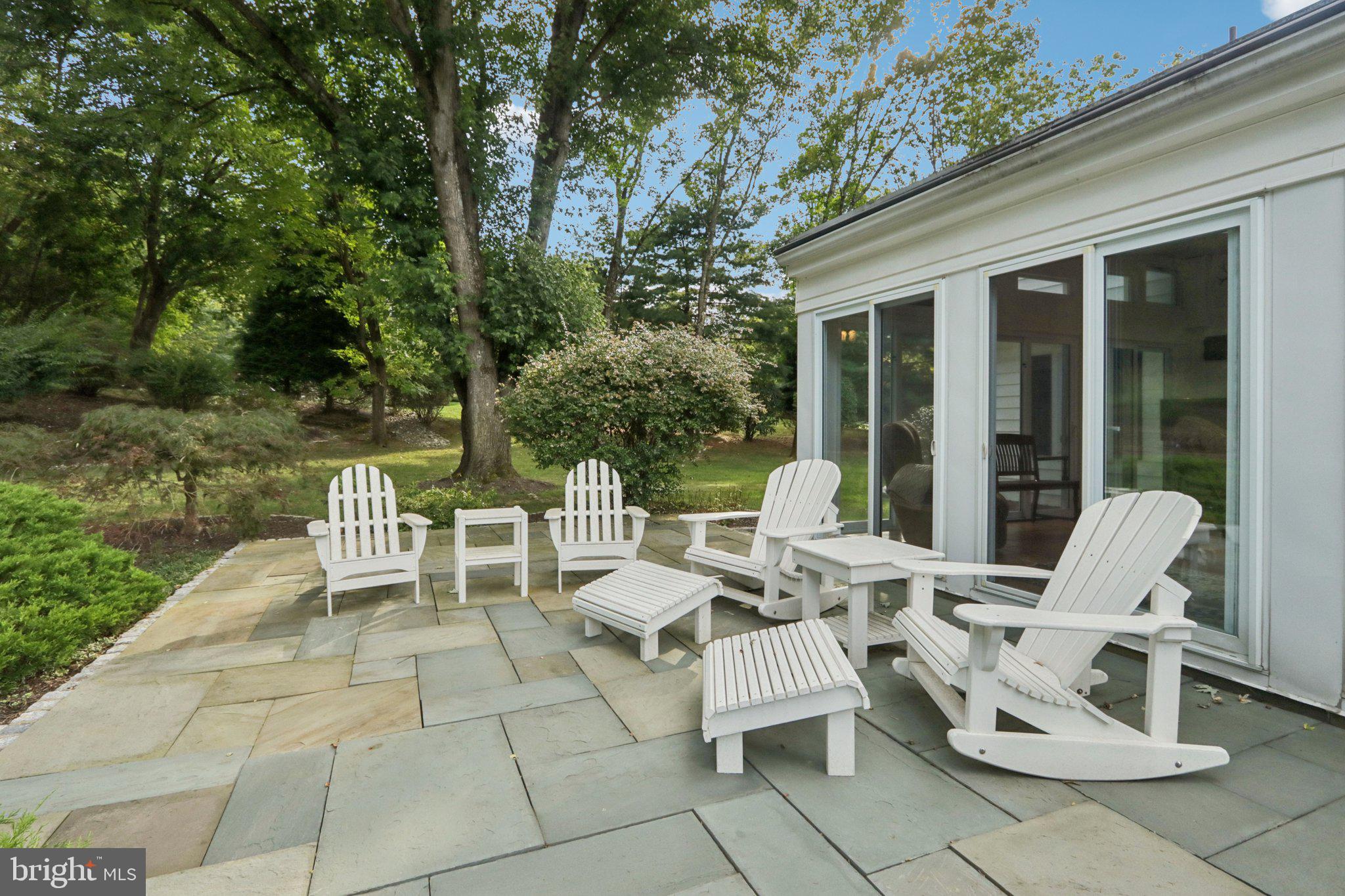294 Batleson Road Ambler, PA 19002 - Photo 41 of 50 a view of a patio with a dining table and chairs with two large trees