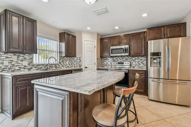a kitchen with granite countertop a sink and a wooden floor