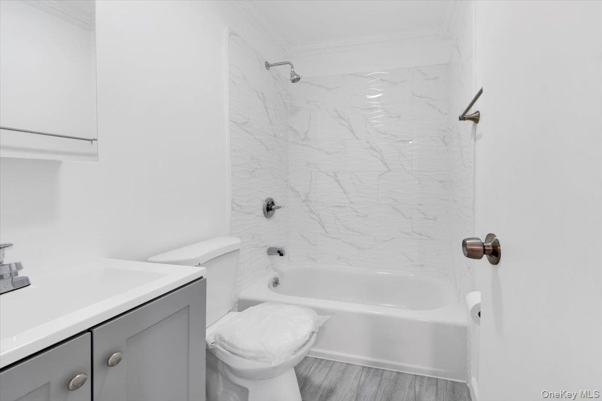 437 Torry Avenue, Unit 2 Bronx, NY 10473 - Photo 7 of 16 Bathroom with vanity, shower / bathtub combination, ornamental molding, and light wood finished floors