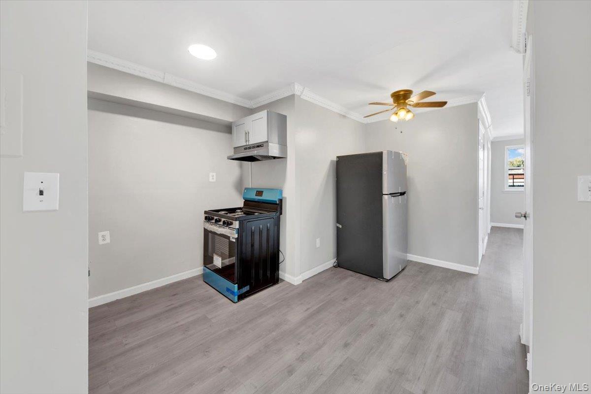 437 Torry Avenue, Unit 2 Bronx, NY 10473 - Photo 9 of 16 Kitchen with gas range oven, freestanding refrigerator, ceiling fan, light wood-style flooring, and under cabinet range hood