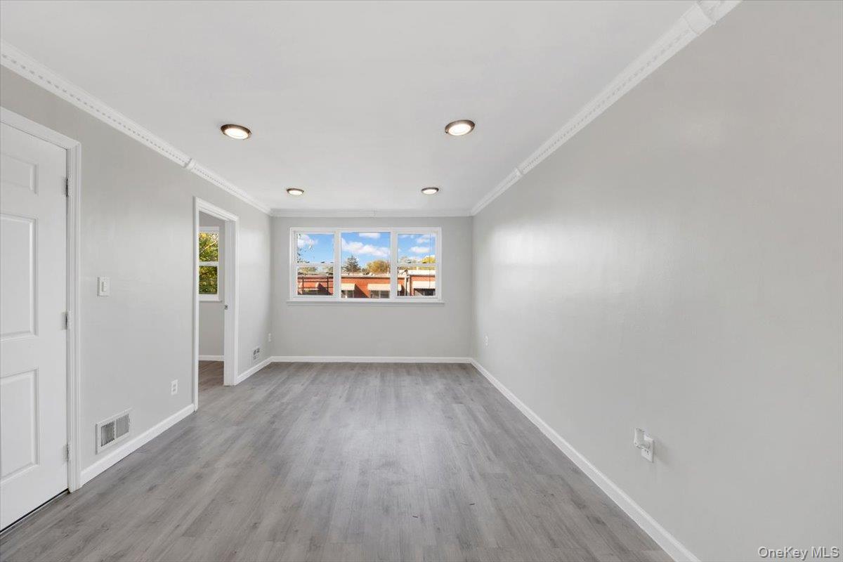 437 Torry Avenue, Unit 2 Bronx, NY 10473 - Photo 10 of 16 Spare room with light wood-type flooring and crown molding