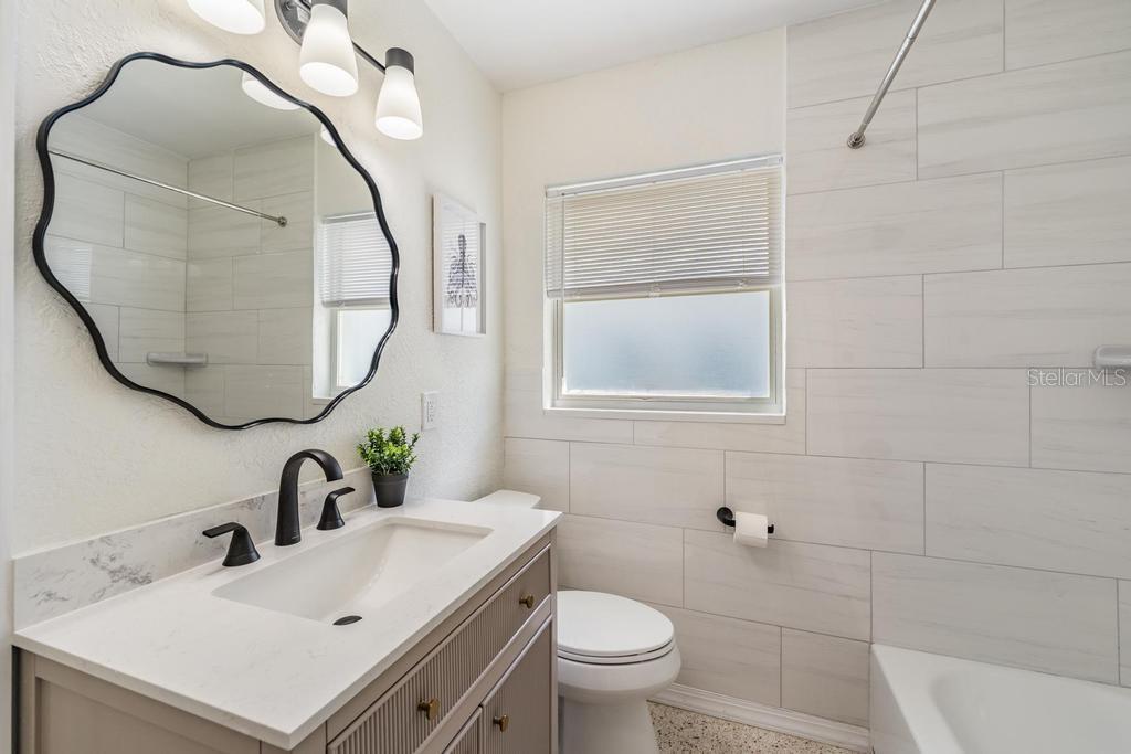 11305 5th Street East Treasure Island, FL 33706 - Photo 18 of 40 a bathroom with a sink mirror and toilet