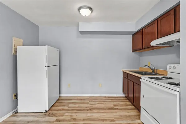 a kitchen with a refrigerator and a stove top oven
