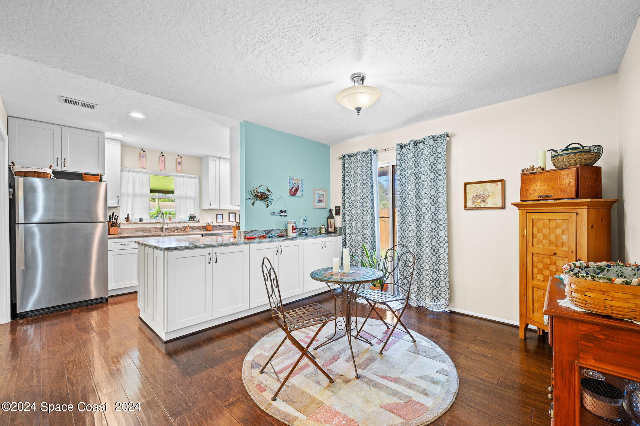 897 Brunswick Lane Rockledge, FL 32955 - Photo 12 of 41 a kitchen with stainless steel appliances granite countertop a refrigerator a stove a sink dishwasher and white cabinets with wooden floor