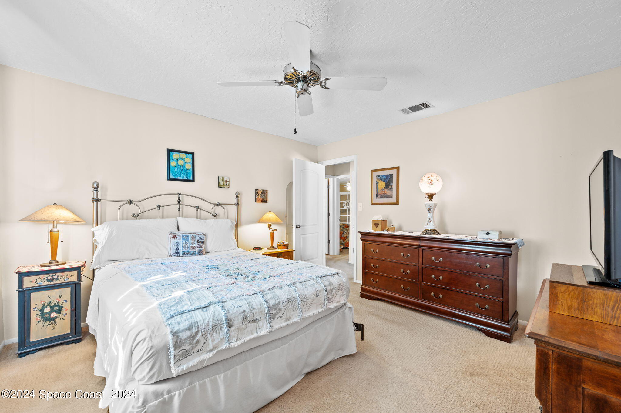 897 Brunswick Lane Rockledge, FL 32955 - Photo 16 of 41 a bedroom with a bed and a flat tv screen on dresser