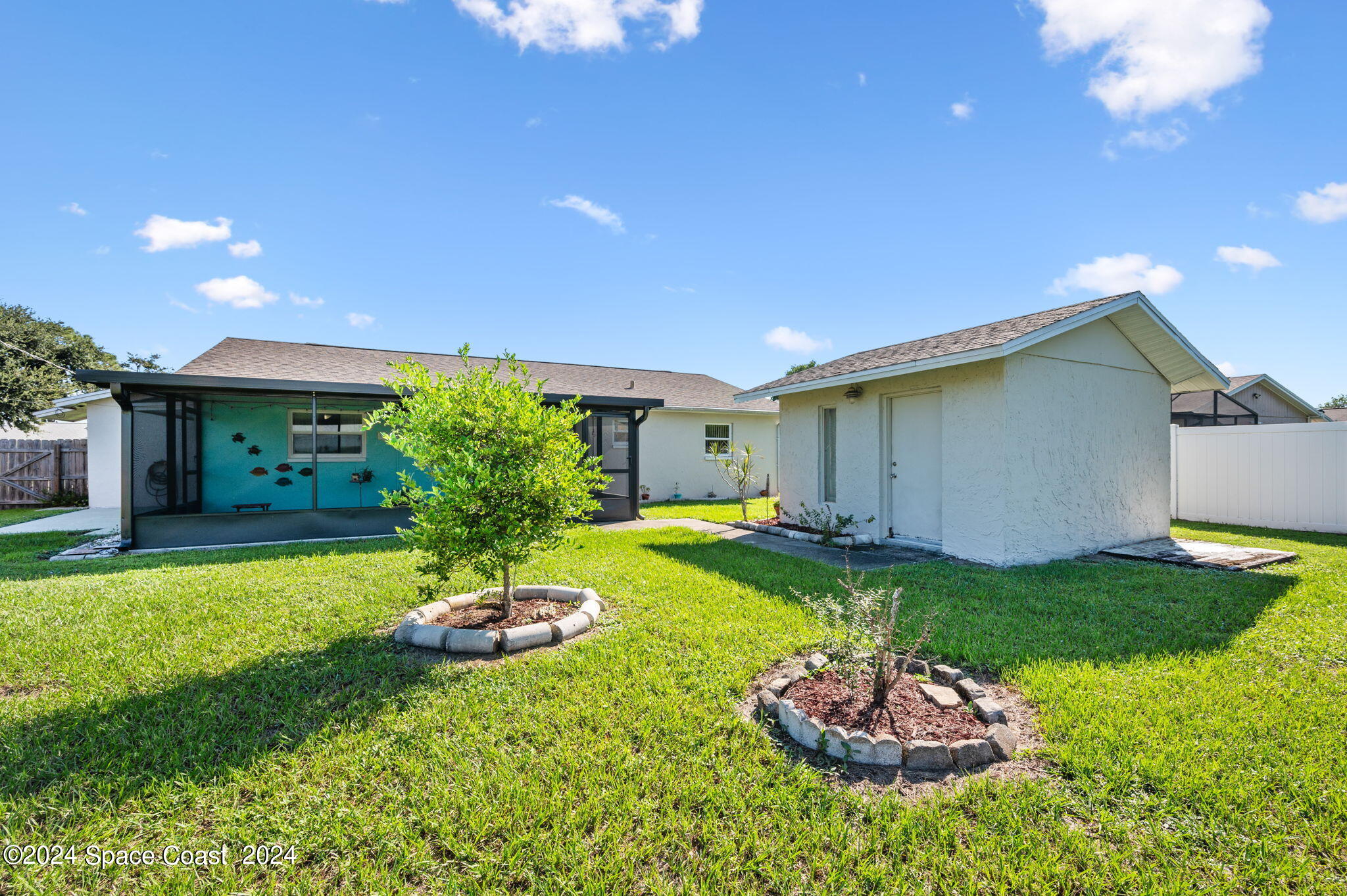 897 Brunswick Lane Rockledge, FL 32955 - Photo 29 of 41 a backyard of a house with a table and chairs plants and large tree