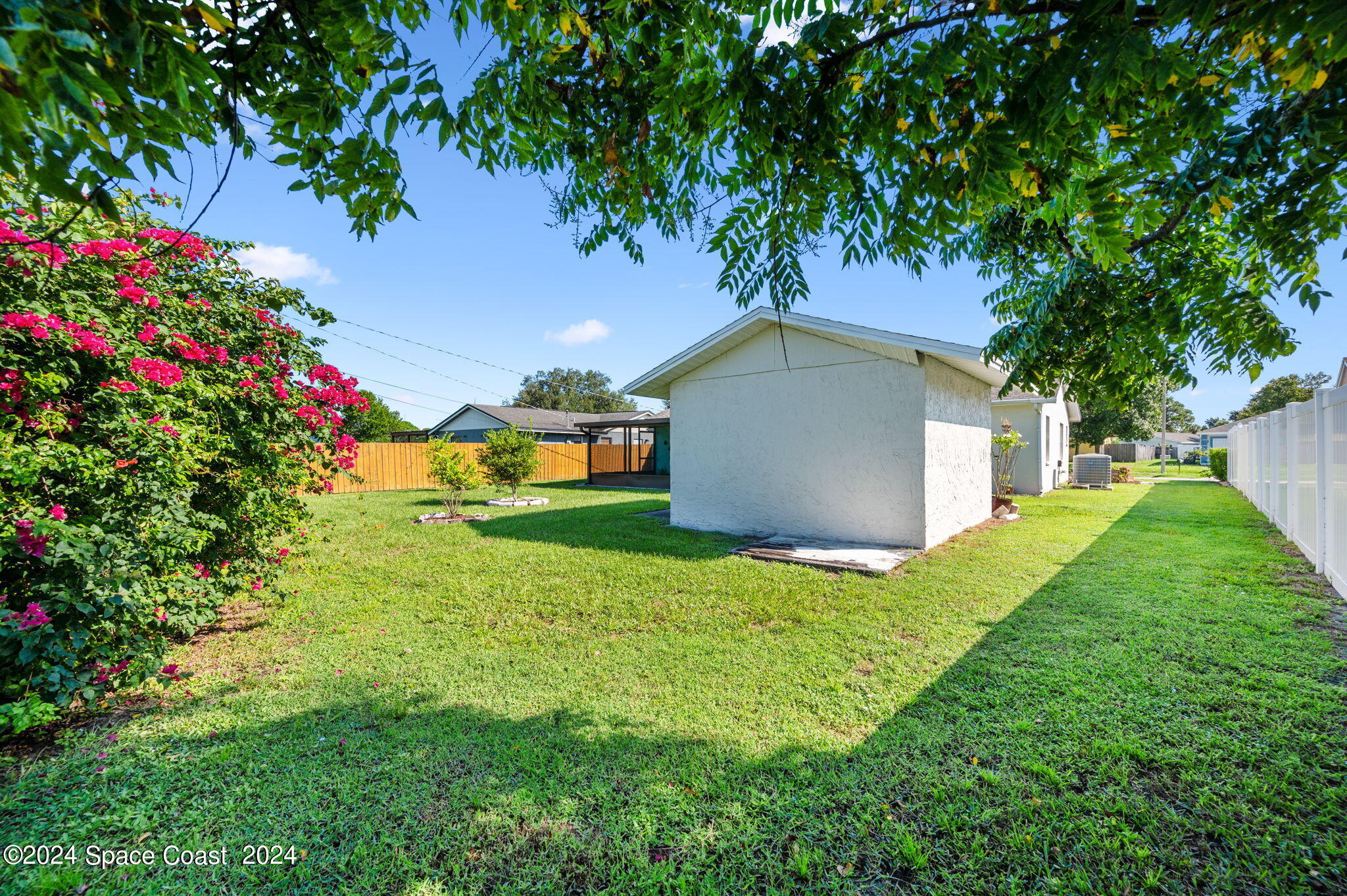 897 Brunswick Lane Rockledge, FL 32955 - Photo 34 of 41 a backyard of a house with table and chairs plants and large tree