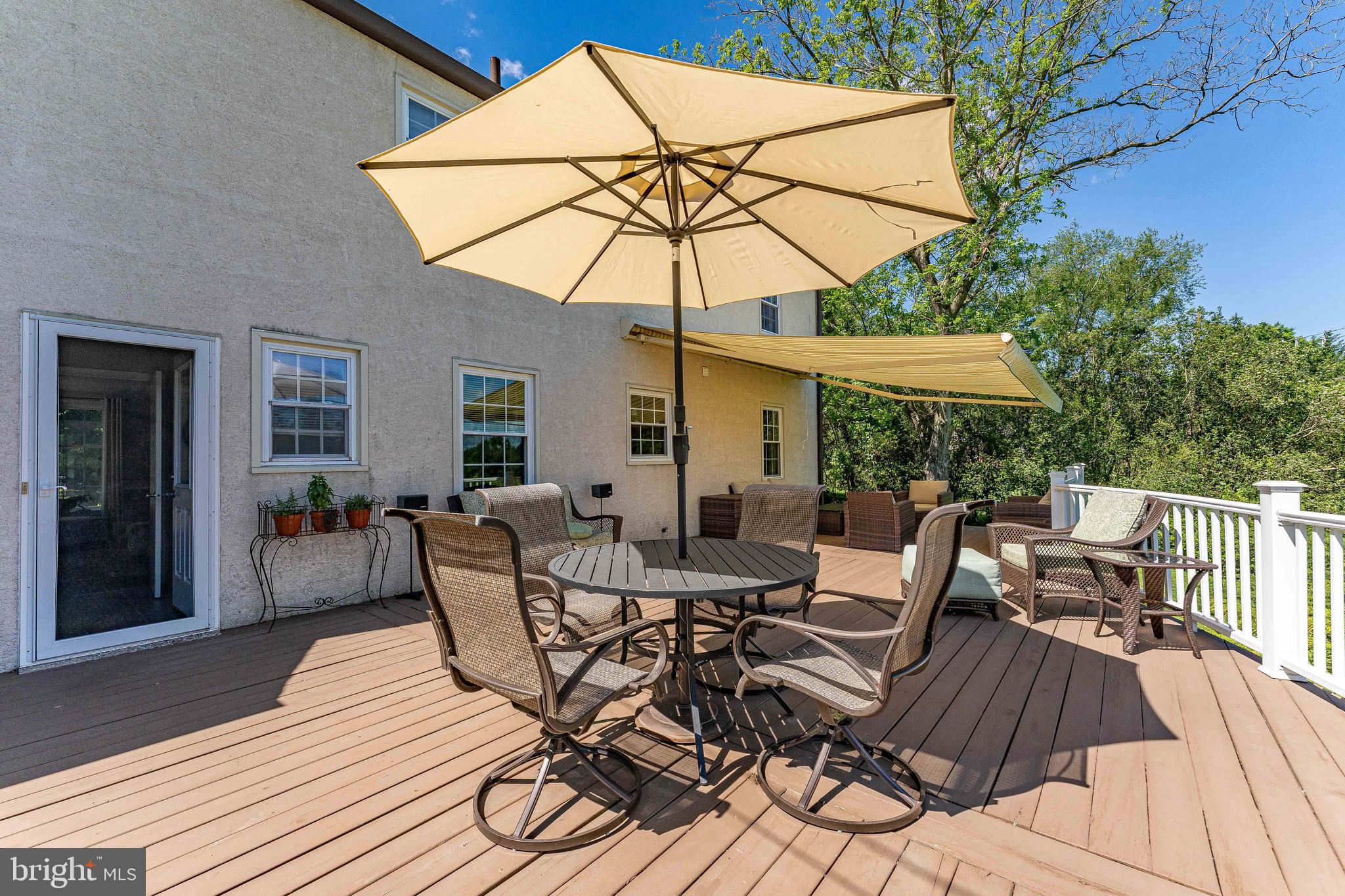 84 North Spring Lane Phoenixville, PA 19460 - Photo 45 of 51 a view of a patio with a dining table and chairs under an umbrella