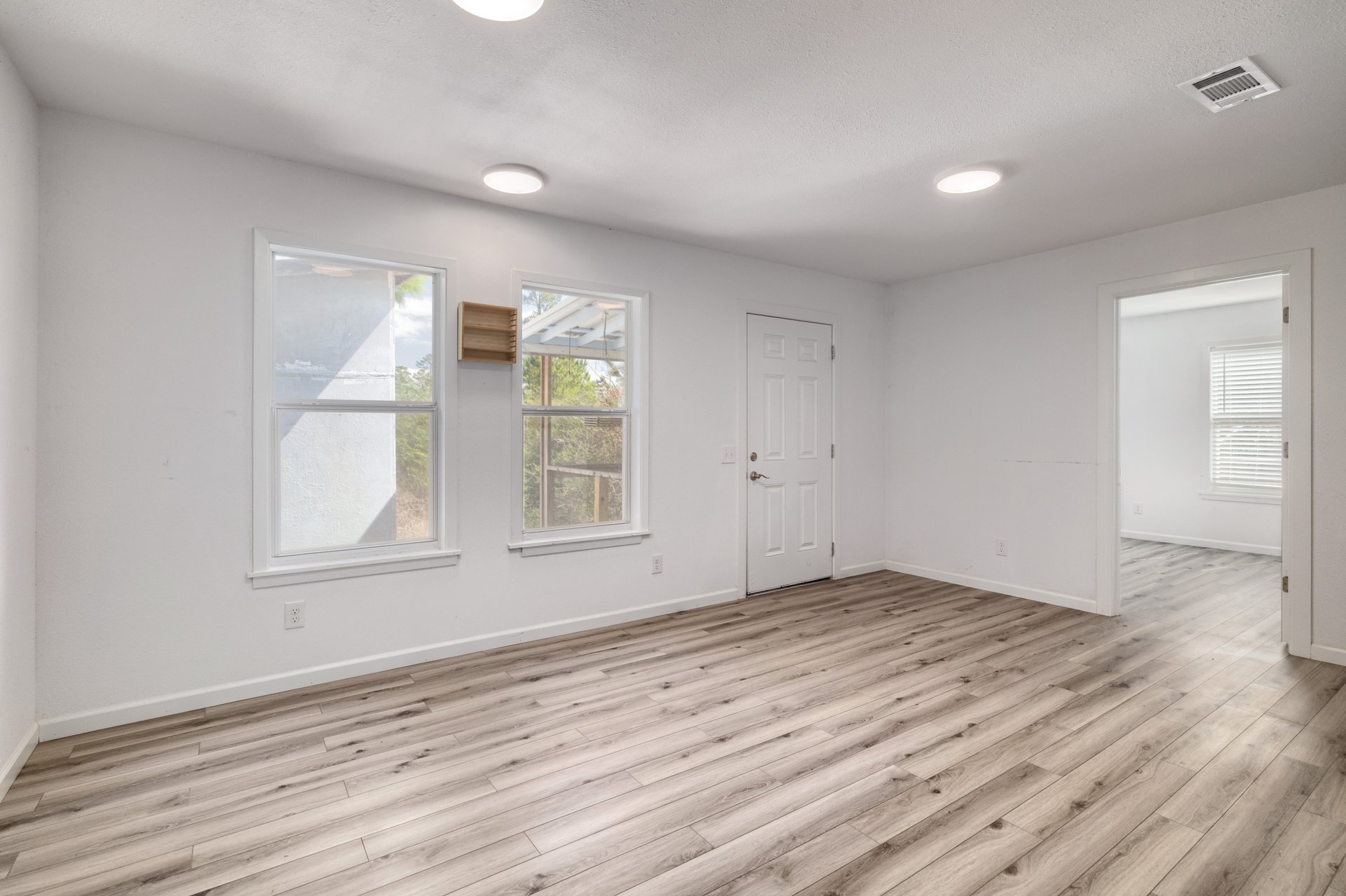 270 Kelley Road West Bastrop, TX 78602 - Photo 7 of 29 an empty room with wooden floor and windows