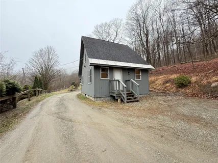 a view of a house with backyard and trees
