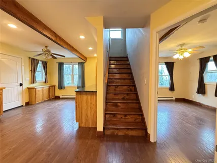 a view of a hallway with wooden floor and staircase