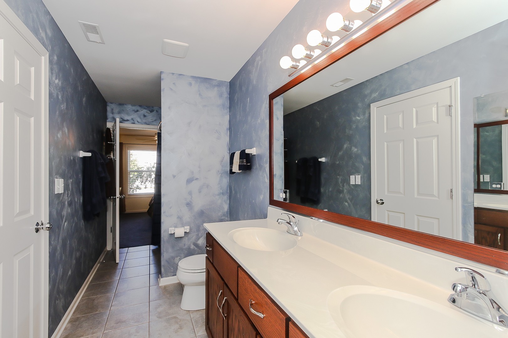 617 West Ruhl Road Palatine, IL 60074 - Photo 30 of 47 a en suite bathroom with a double vanity sink and a mirror