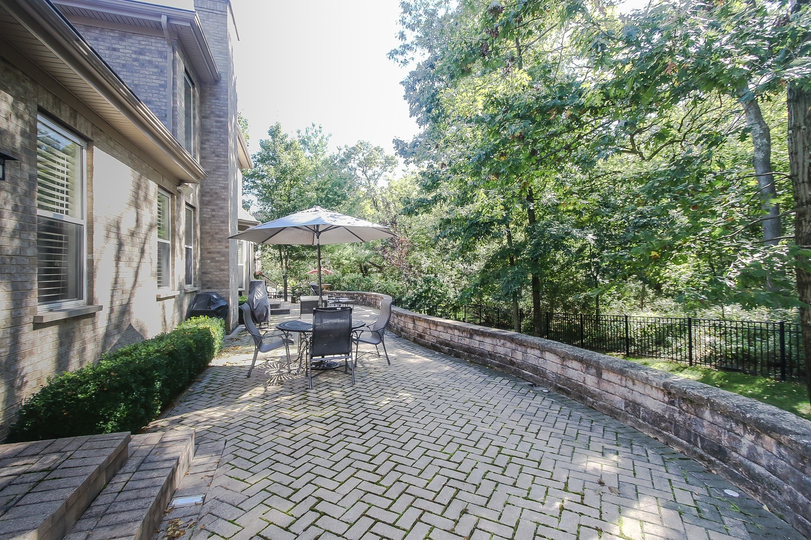617 West Ruhl Road Palatine, IL 60074 - Photo 40 of 47 a view of a patio with table and chairs under an umbrella with large trees