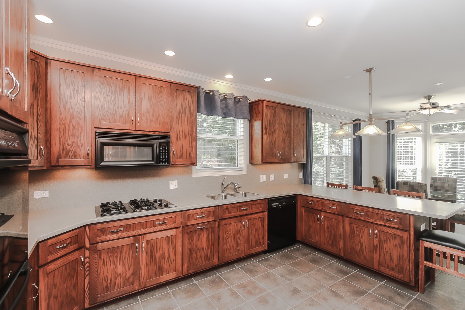 617 West Ruhl Road Palatine, IL 60074 - Photo 10 of 47 a large kitchen with stainless steel appliances wooden cabinets a stove a sink and a microwave