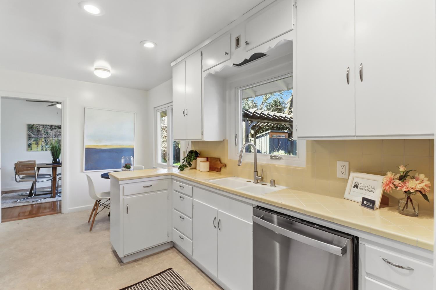 709 A Street Davis, CA 95616 - Photo 25 of 74 a kitchen with a sink dishwasher and white cabinets with wooden floor