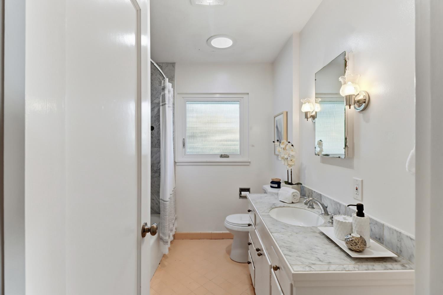 709 A Street Davis, CA 95616 - Photo 32 of 74 a bathroom with a granite countertop sink a toilet and a mirror