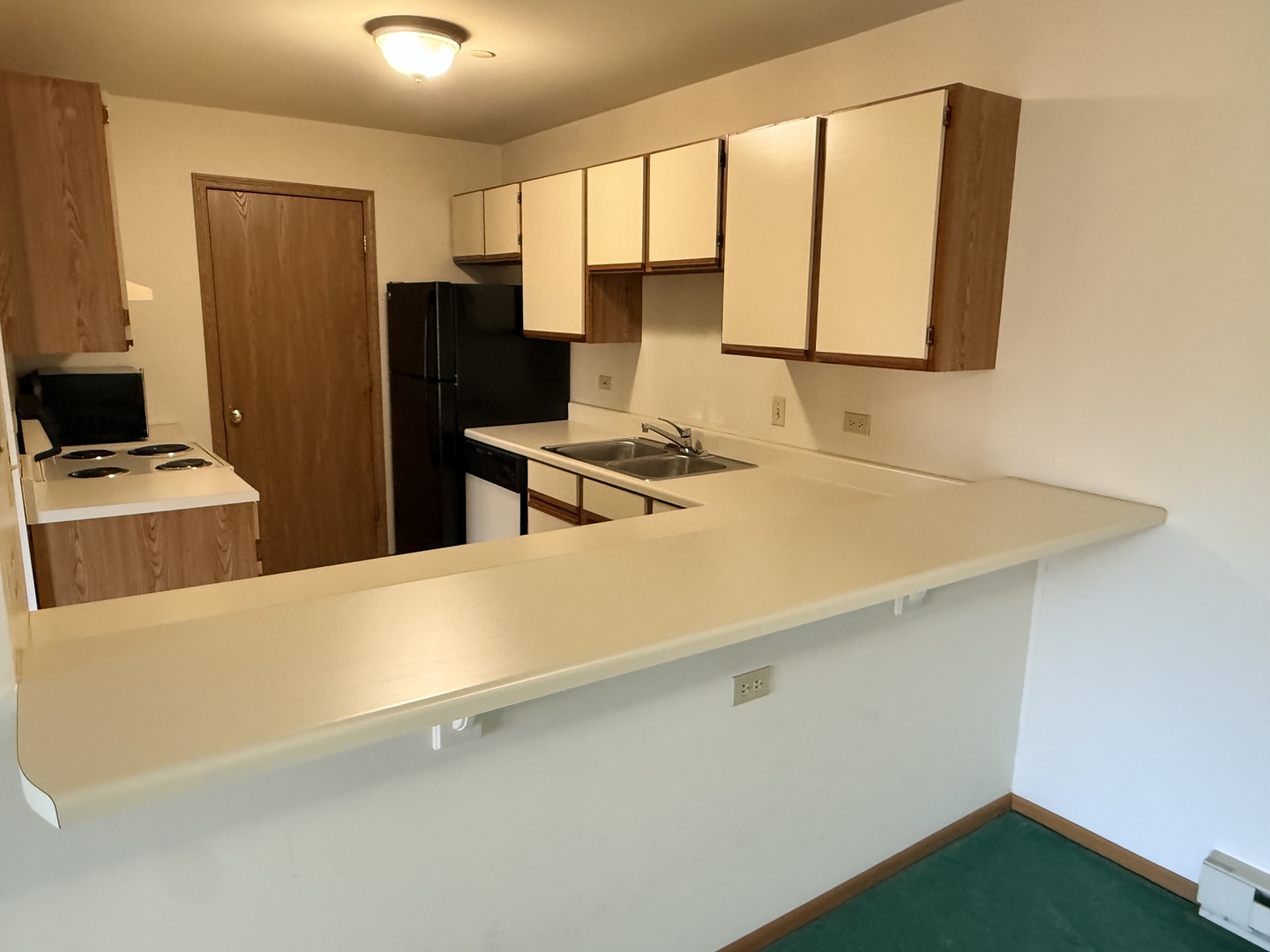 1345 Cunat Court, Unit 1B Lake In The Hills, IL 60156 - Photo 4 of 16 a room with a sink a stove and a refrigerator