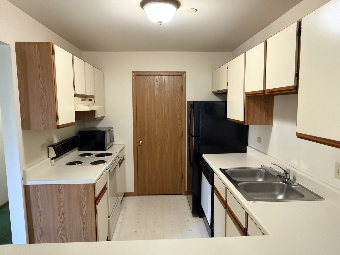 1345 Cunat Court, Unit 1B Lake In The Hills, IL 60156 - Photo 5 of 16 a kitchen that has a sink a refrigerator and a stove top oven