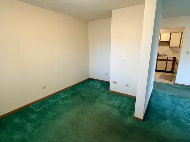 a view of an empty room and kitchen