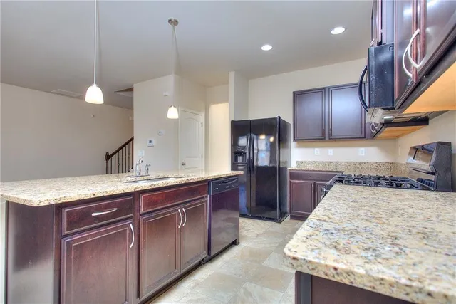 a kitchen with a sink a counter top space appliances and cabinets